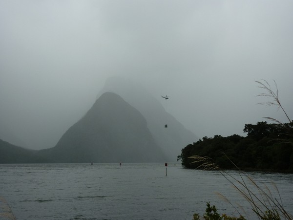 The helicopter carrying panels passes by Mitre Peak